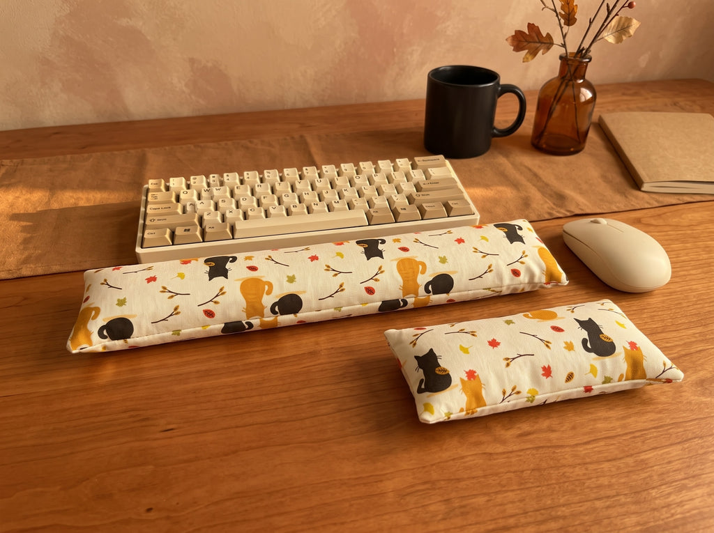 Autumn black cat wrist rest set in front of a keyboard on a warm wood desk