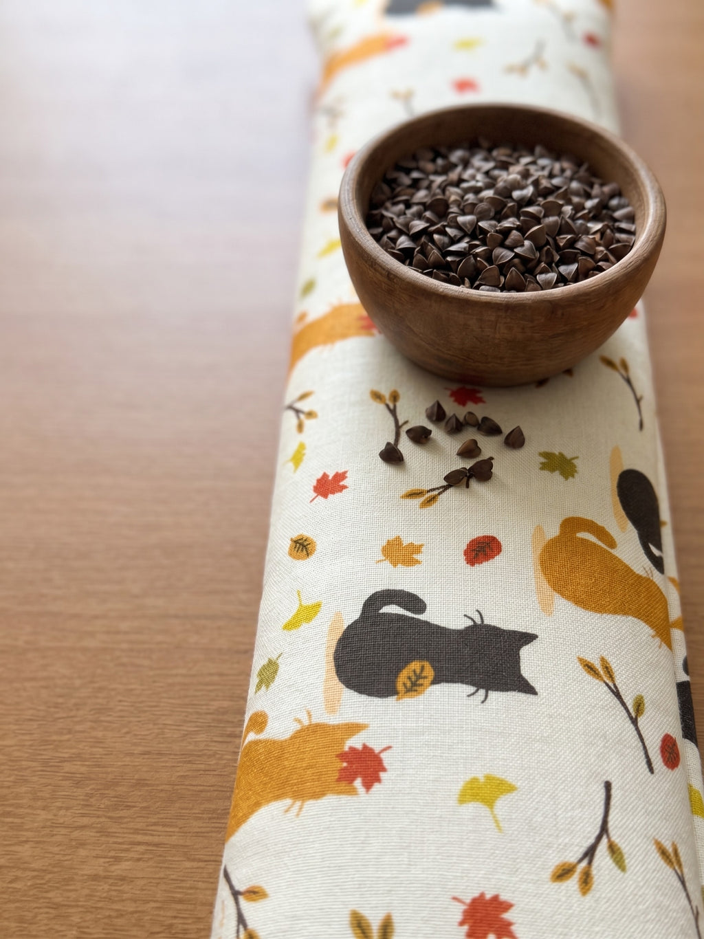 Autumn black cat wrist rest with a bowl of the buckwheat hulls used as filling