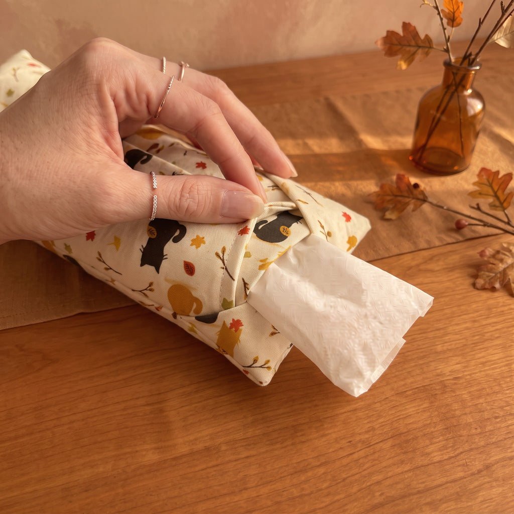 Hand sliding the white inner bag of buckwheat hulls out of the autumn cat print cover