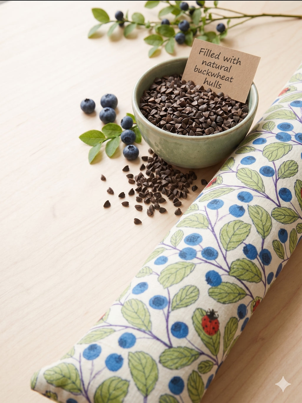 Blueberry ladybug wrist rest beside a bowl of buckwheat hulls, the natural filling
