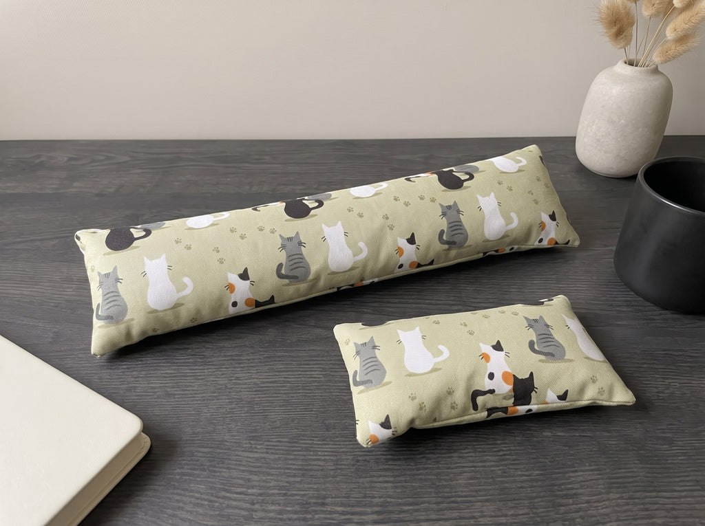 The two pieces of the sage green calico cat family set, a keyboard wrist rest and a mouse wrist rest