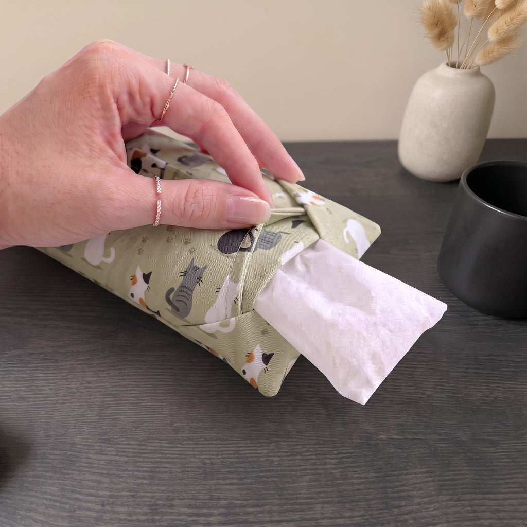 Hand sliding the white inner bag of buckwheat hulls out of the sage green cat print cover