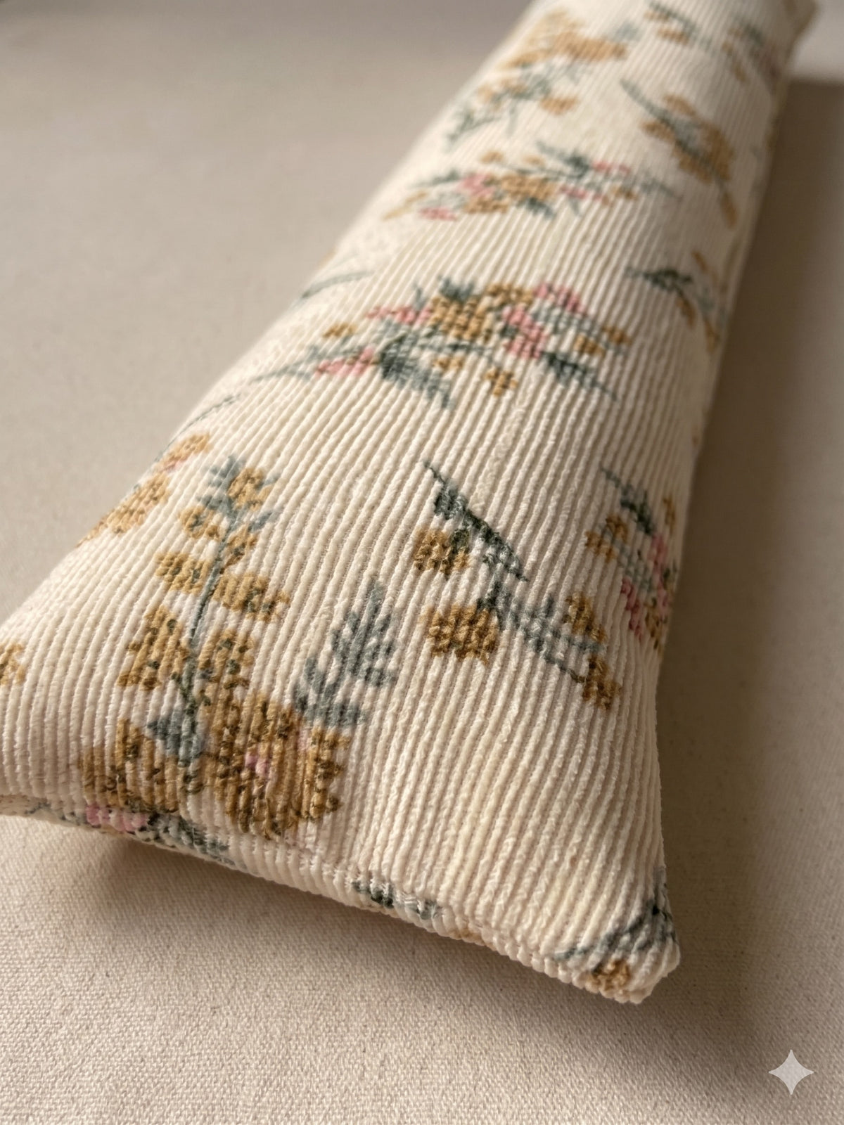 Close-up of the ribbed cream corduroy and its small vintage flowers