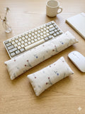 Ditsy floral linen keyboard and mouse wrist rests with a keyboard and mouse on a wooden desk