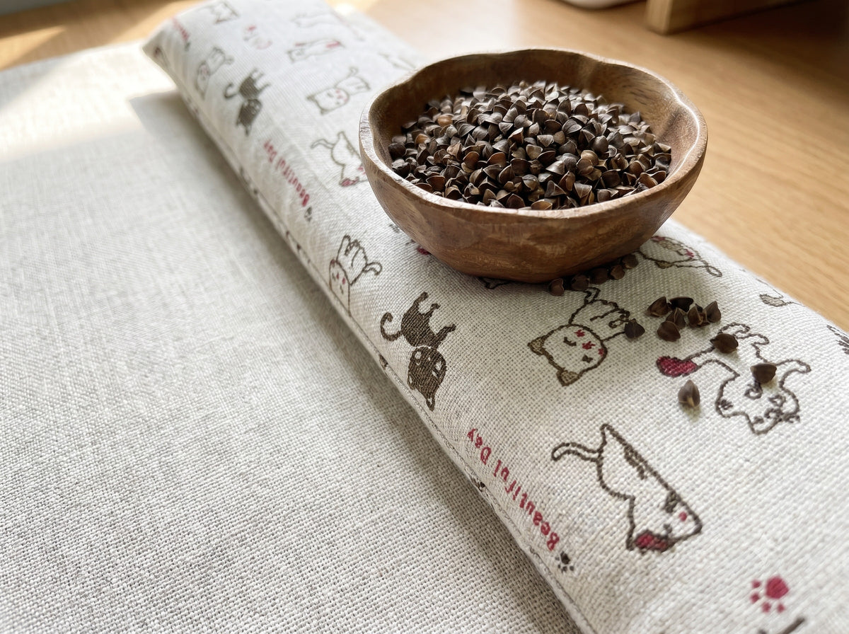 Natural doodle cat wrist rest with a bowl of the buckwheat hulls used as filling