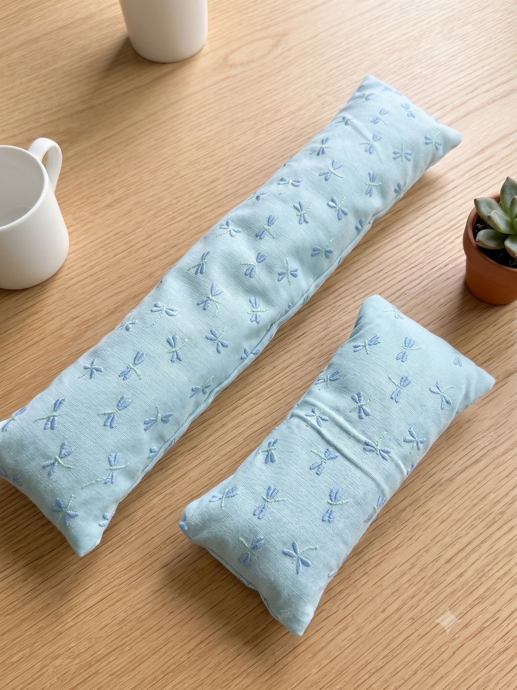 The two pieces of the embroidered dragonfly set, a keyboard wrist rest and a mouse wrist rest