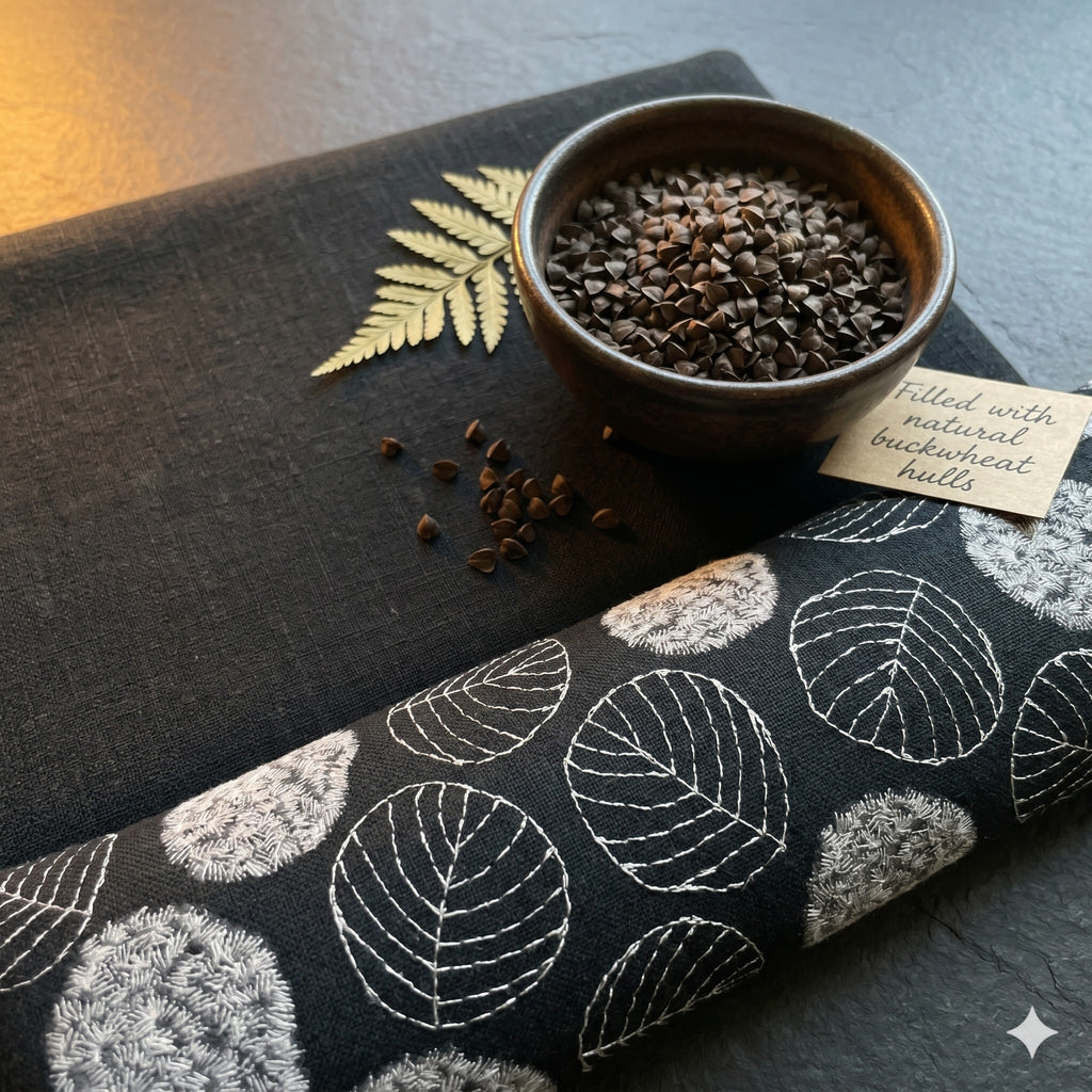 Black embroidered leaf wrist rest with a bowl of buckwheat hulls