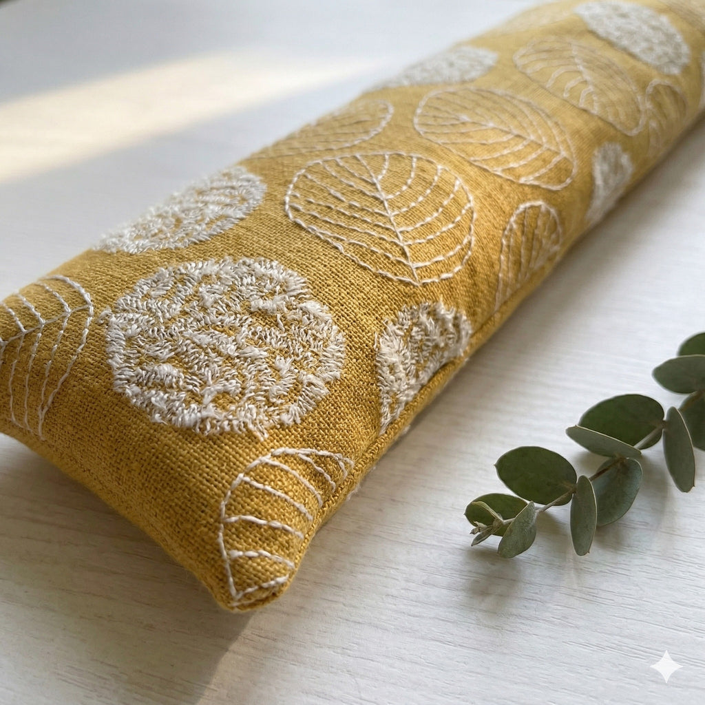 Close-up of cream leaf embroidery on the mustard yellow wrist rest