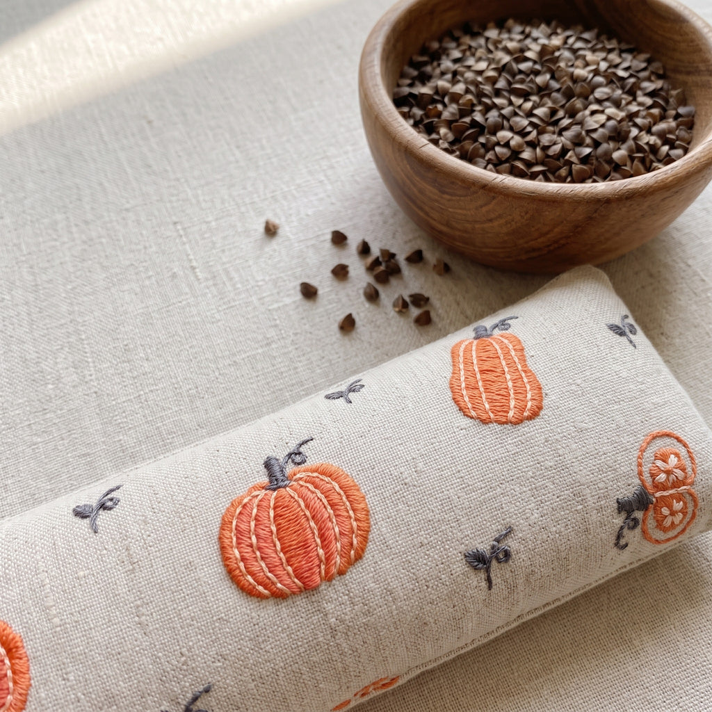 Cream pumpkin wrist rest with a bowl of the buckwheat hulls used as filling