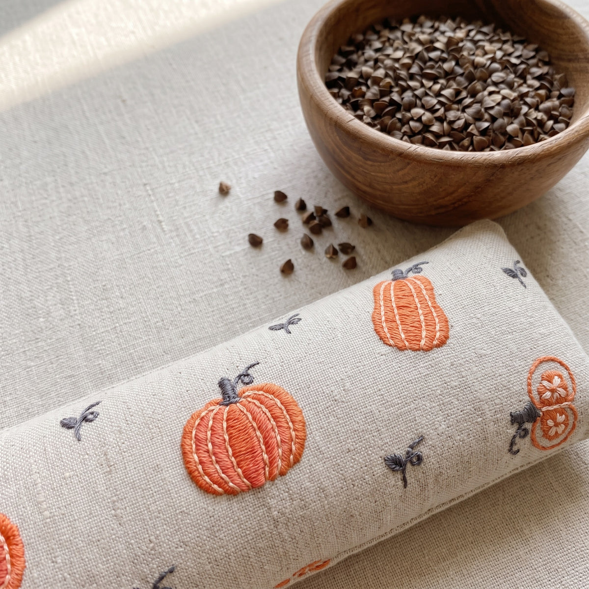 Cream pumpkin wrist rest with a bowl of the buckwheat hulls used as filling