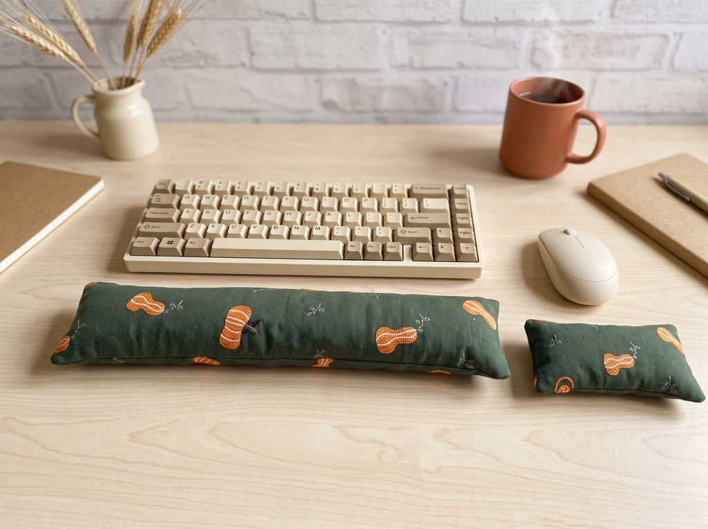 Forest green pumpkin wrist rest set in front of a keyboard with a mug and dried wheat