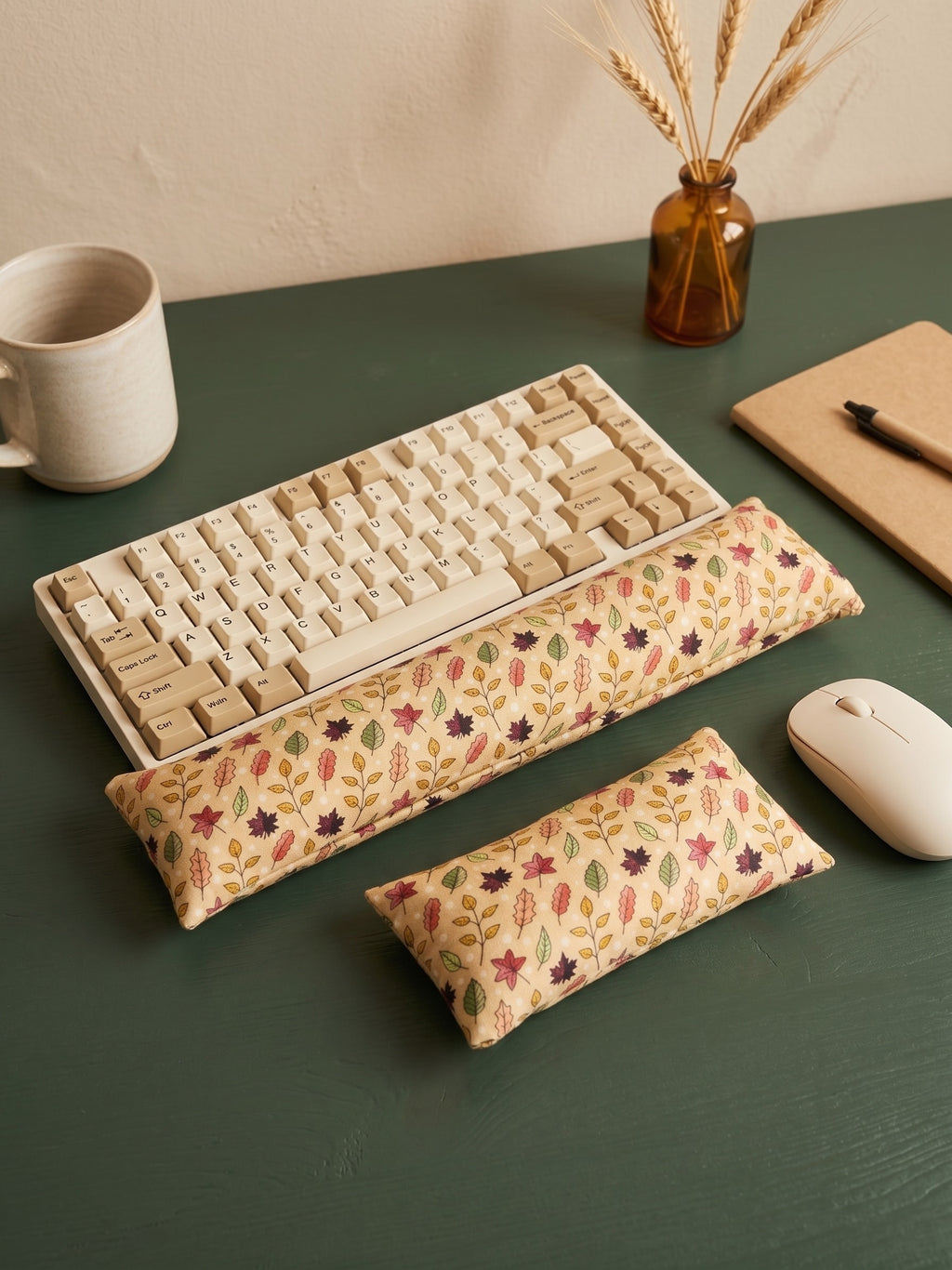Fall maple leaf keyboard and mouse wrist rests around a keyboard on a dark green desk