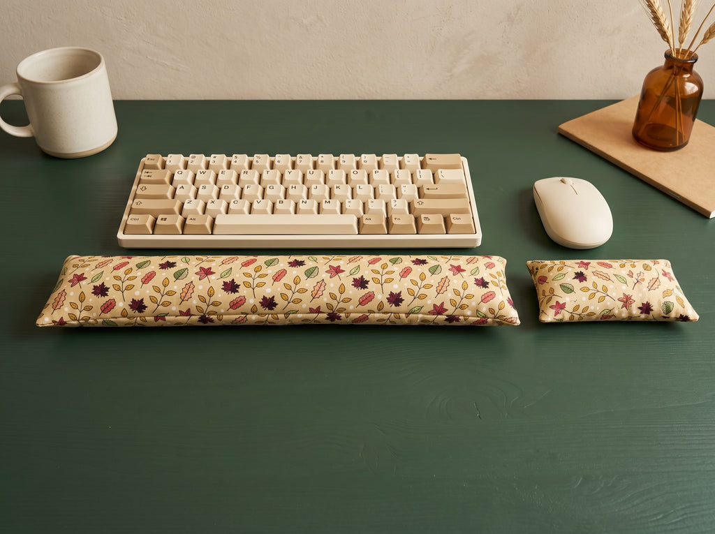 Fall maple leaf wrist rest set in front of a keyboard and mouse on a dark green desk