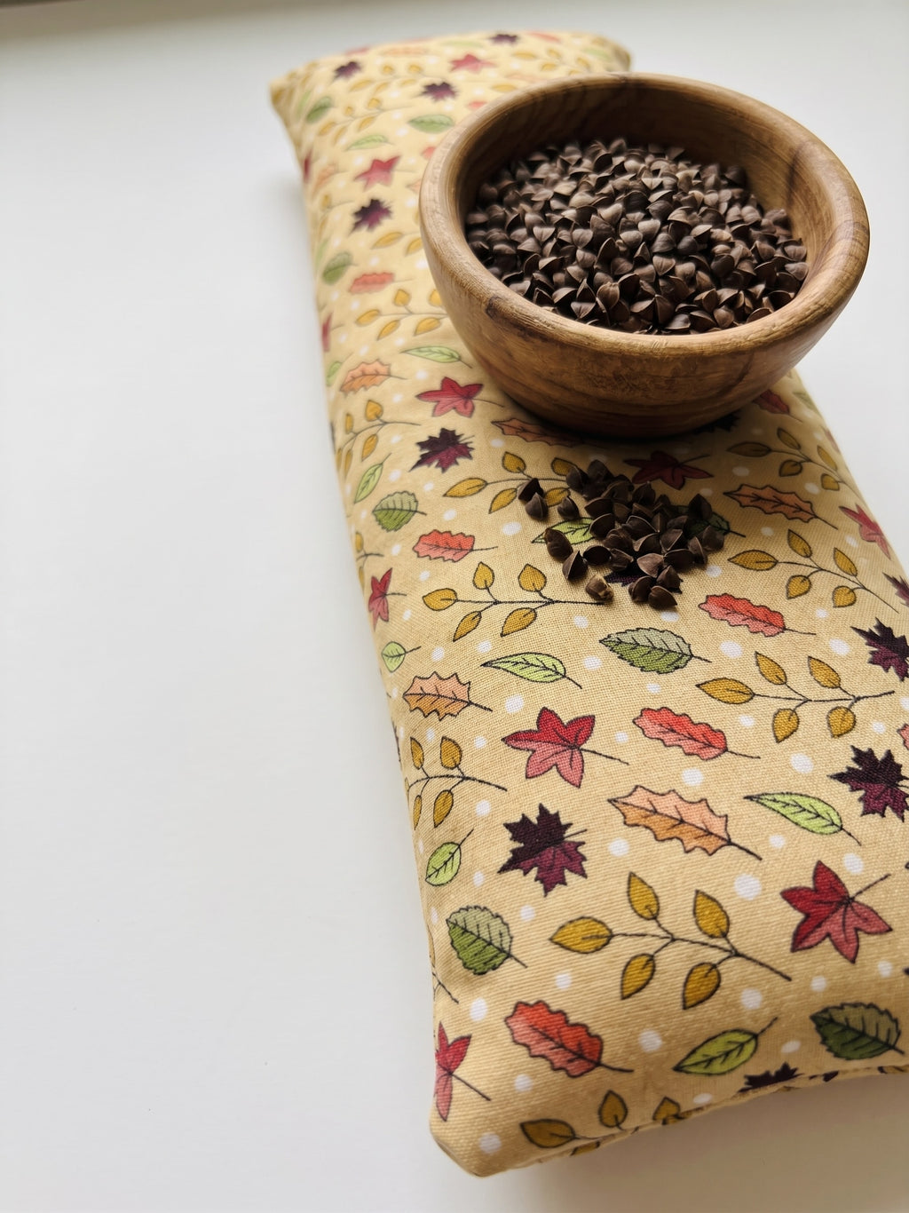Fall maple leaf wrist rest with a bowl of the buckwheat hulls used as filling