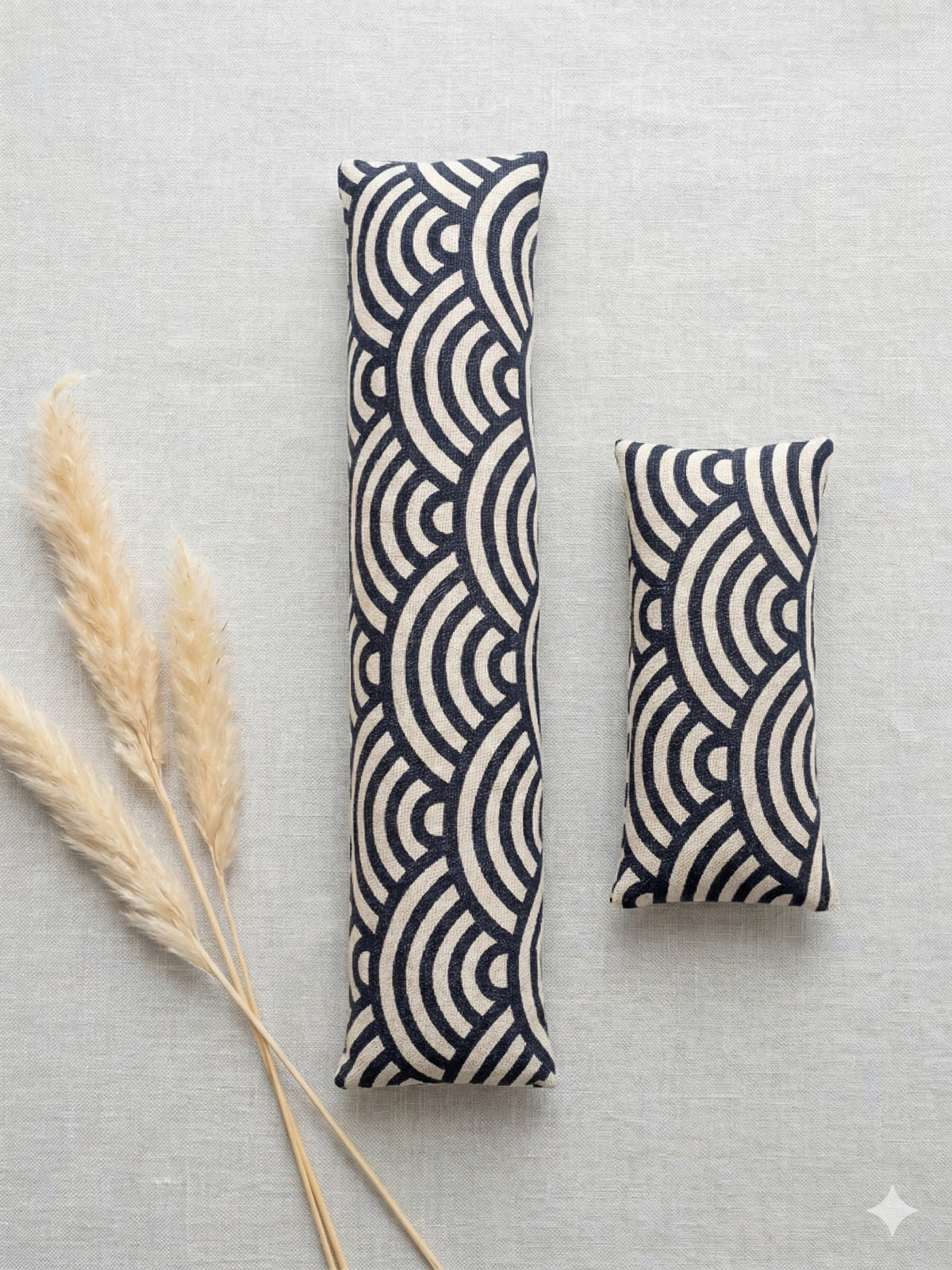 The two pieces of the geometric arc set, a keyboard wrist rest and a mouse wrist rest, with dried grass