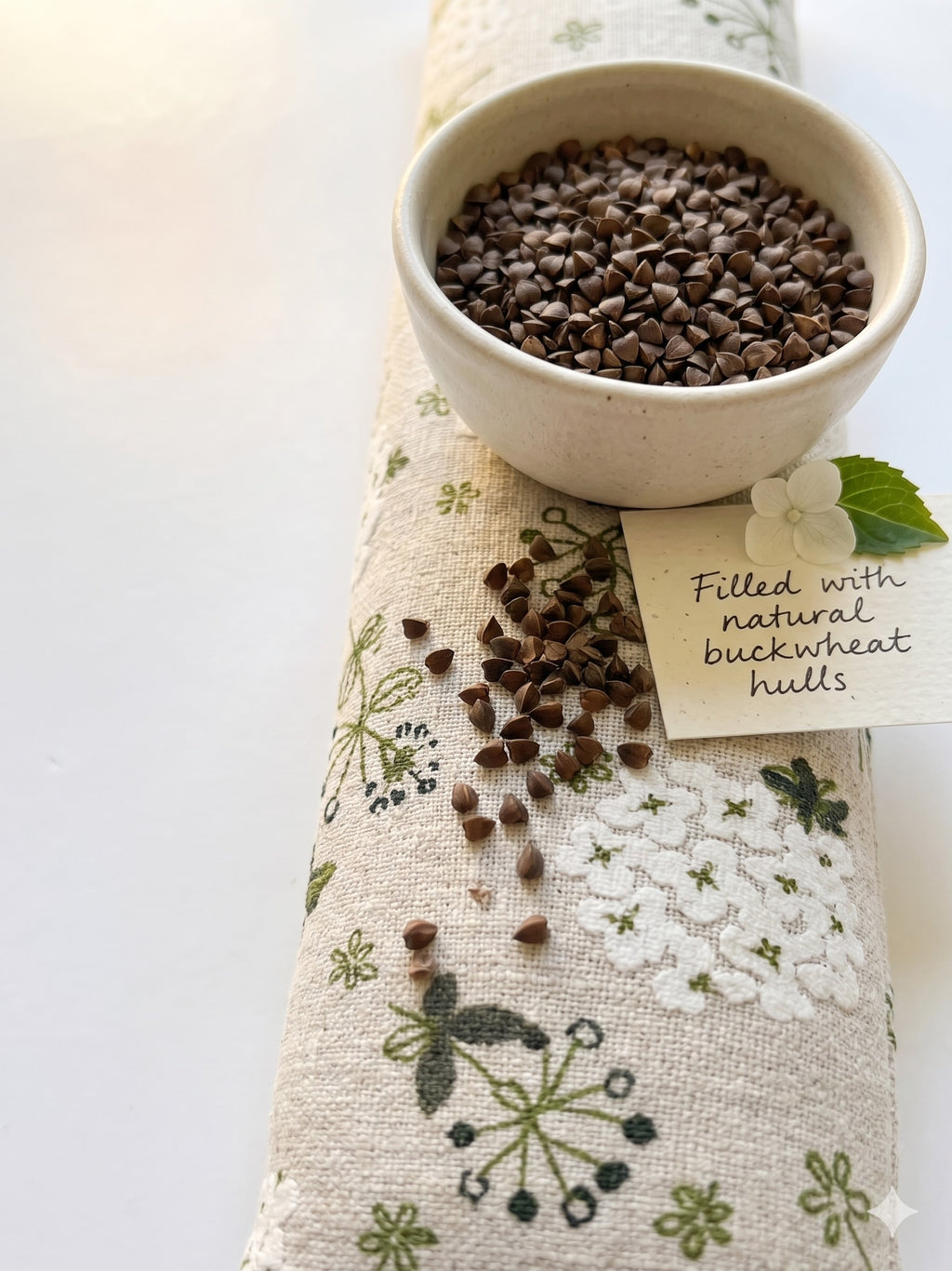 Hydrangea wrist rest with a bowl of buckwheat hulls and a card that reads filled with natural buckwheat hulls