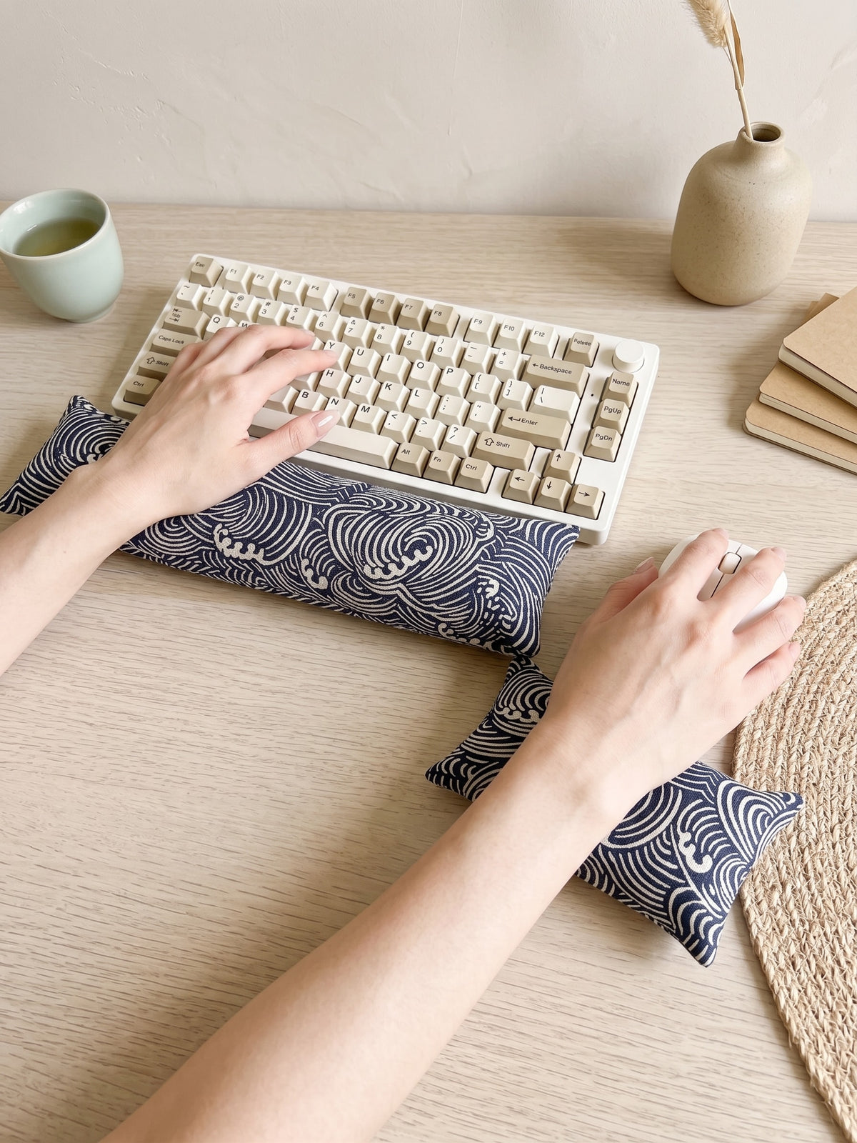 Hands typing on a keyboard above the Japanese wave wrist rest, with the mouse rest beside it
