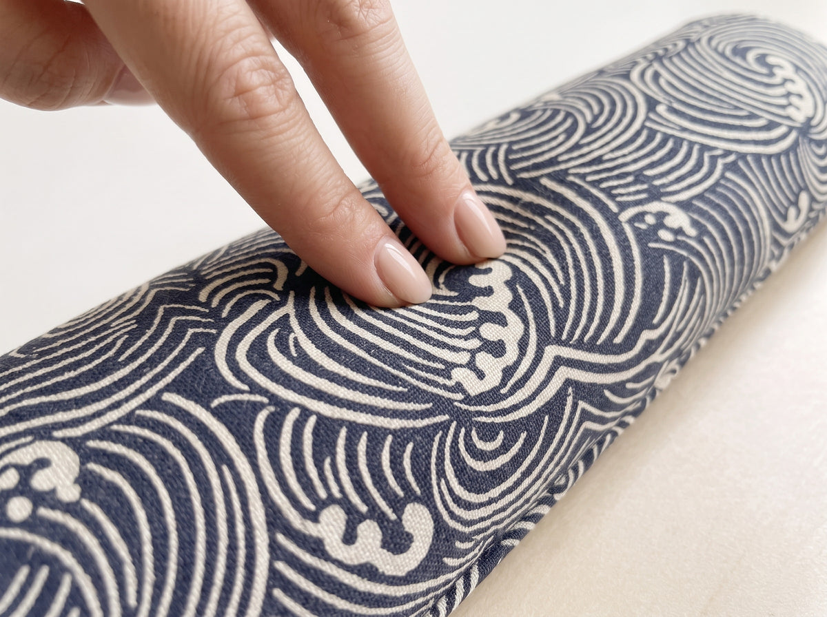 Fingers pressing into the Japanese wave wrist rest to show the buckwheat filling