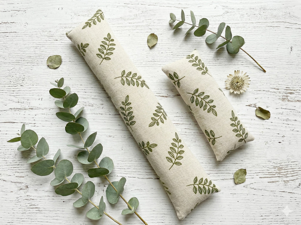 Leaf print keyboard and mouse wrist rests laid flat with eucalyptus sprigs