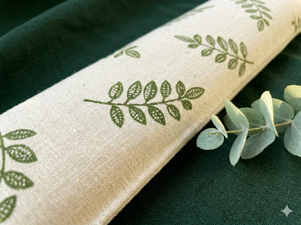 Close-up of green leaf sprigs printed on natural fabric