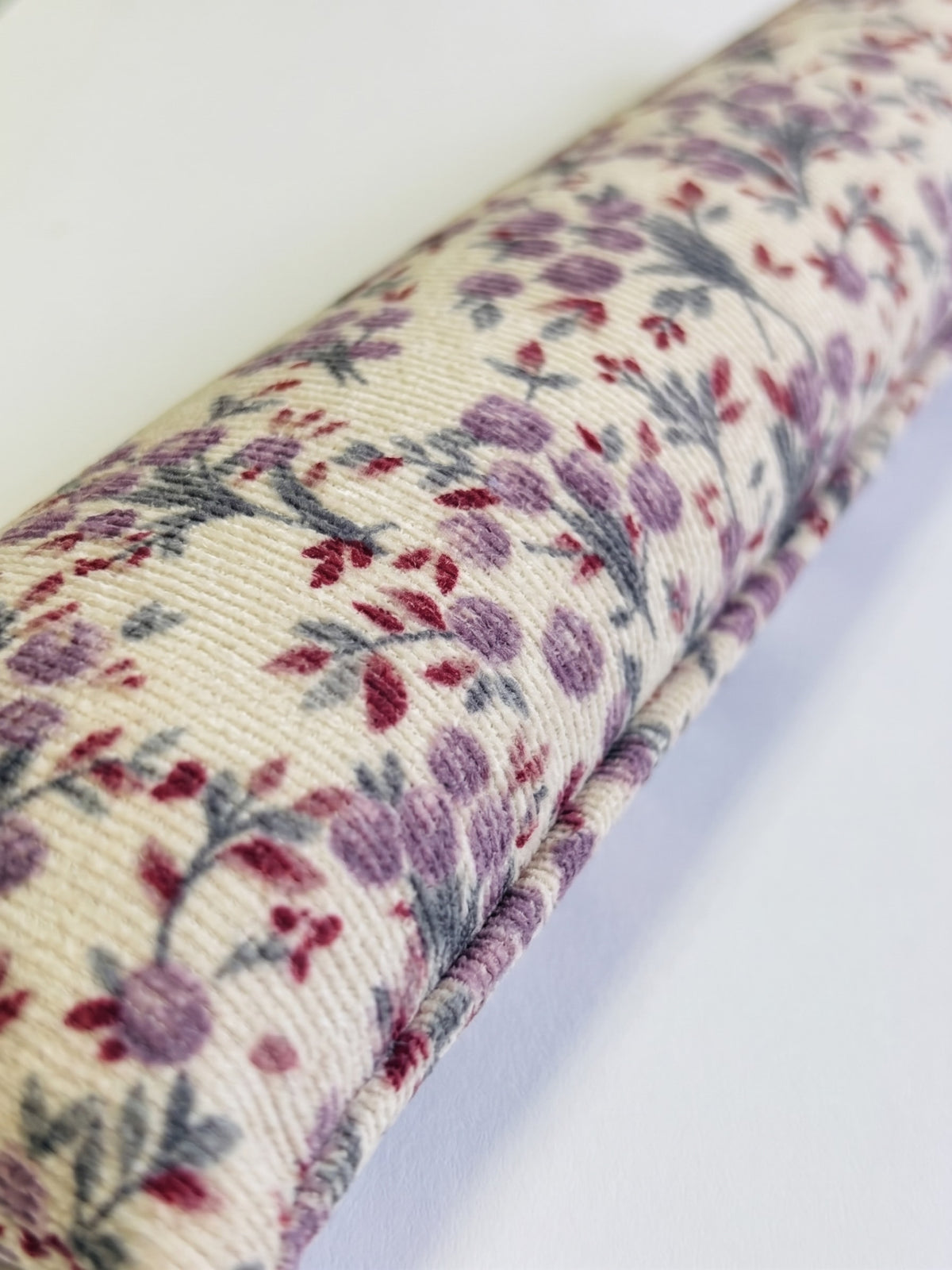 Close-up of the ribbed cream corduroy and its lilac and berry sprigs