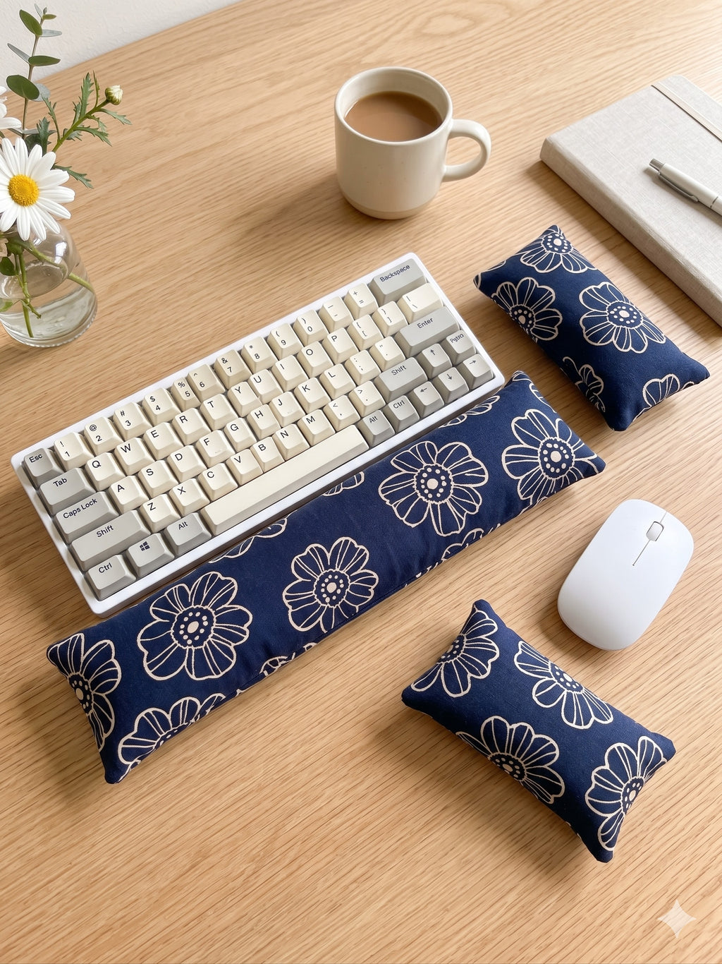 Navy line art daisy keyboard and mouse wrist rests around a keyboard on a wooden desk