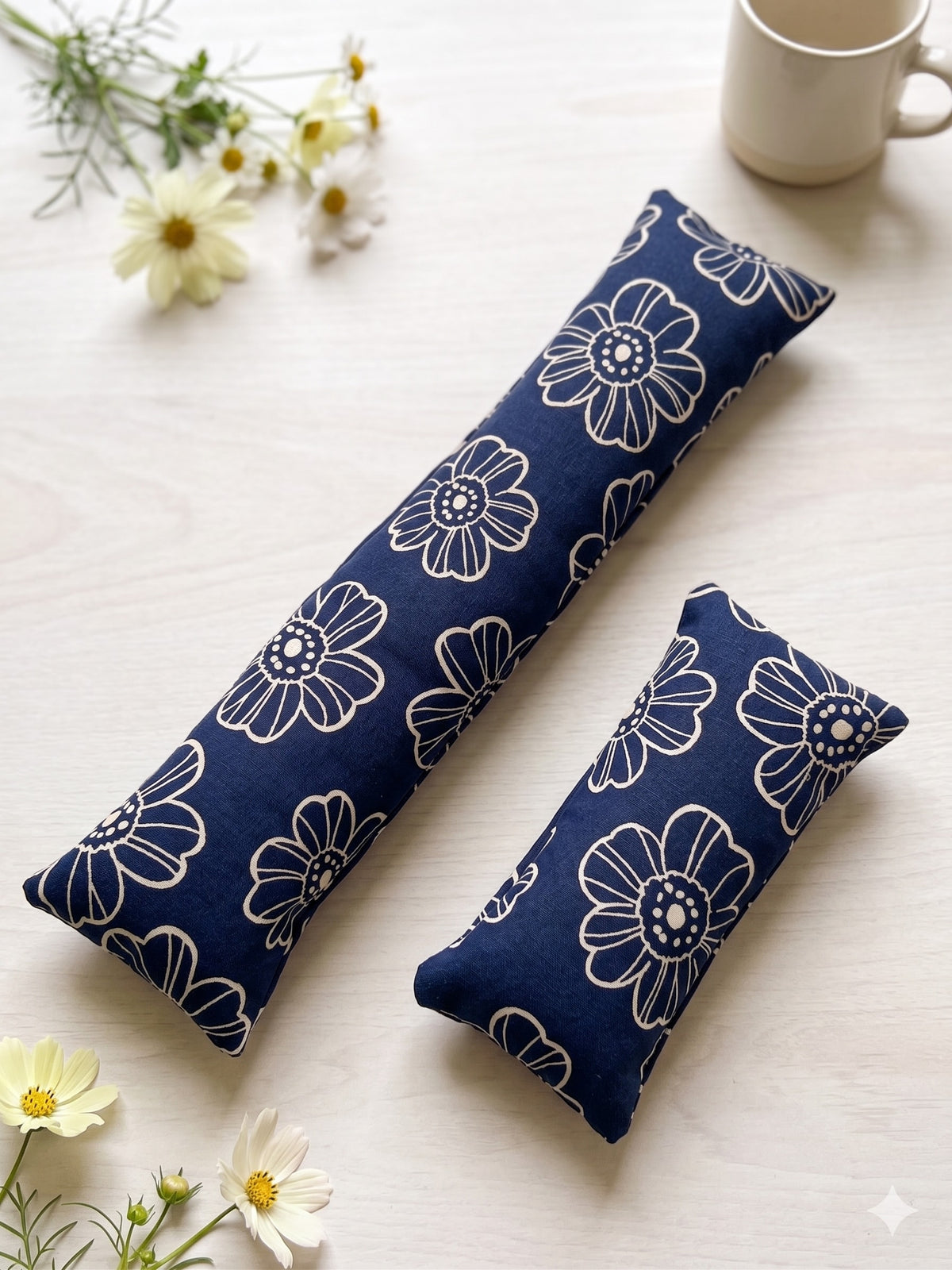 The two pieces of the navy daisy set, a keyboard wrist rest and a mouse wrist rest