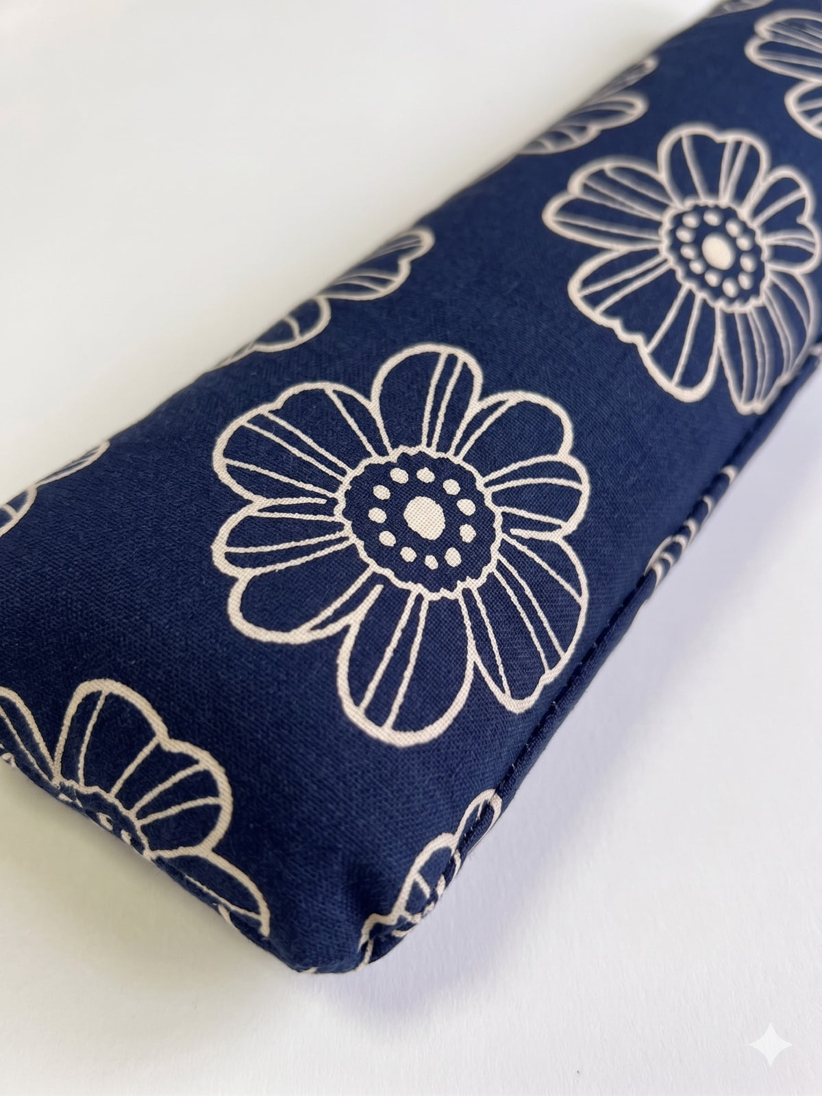Close-up of the white line-drawn daisies on the navy cover