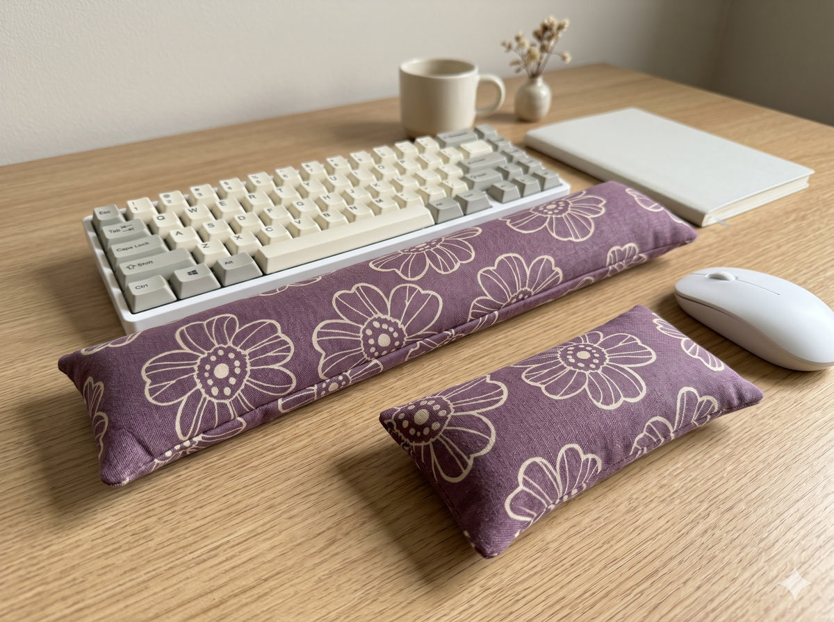 Plum line art daisy keyboard and mouse wrist rests in front of a keyboard