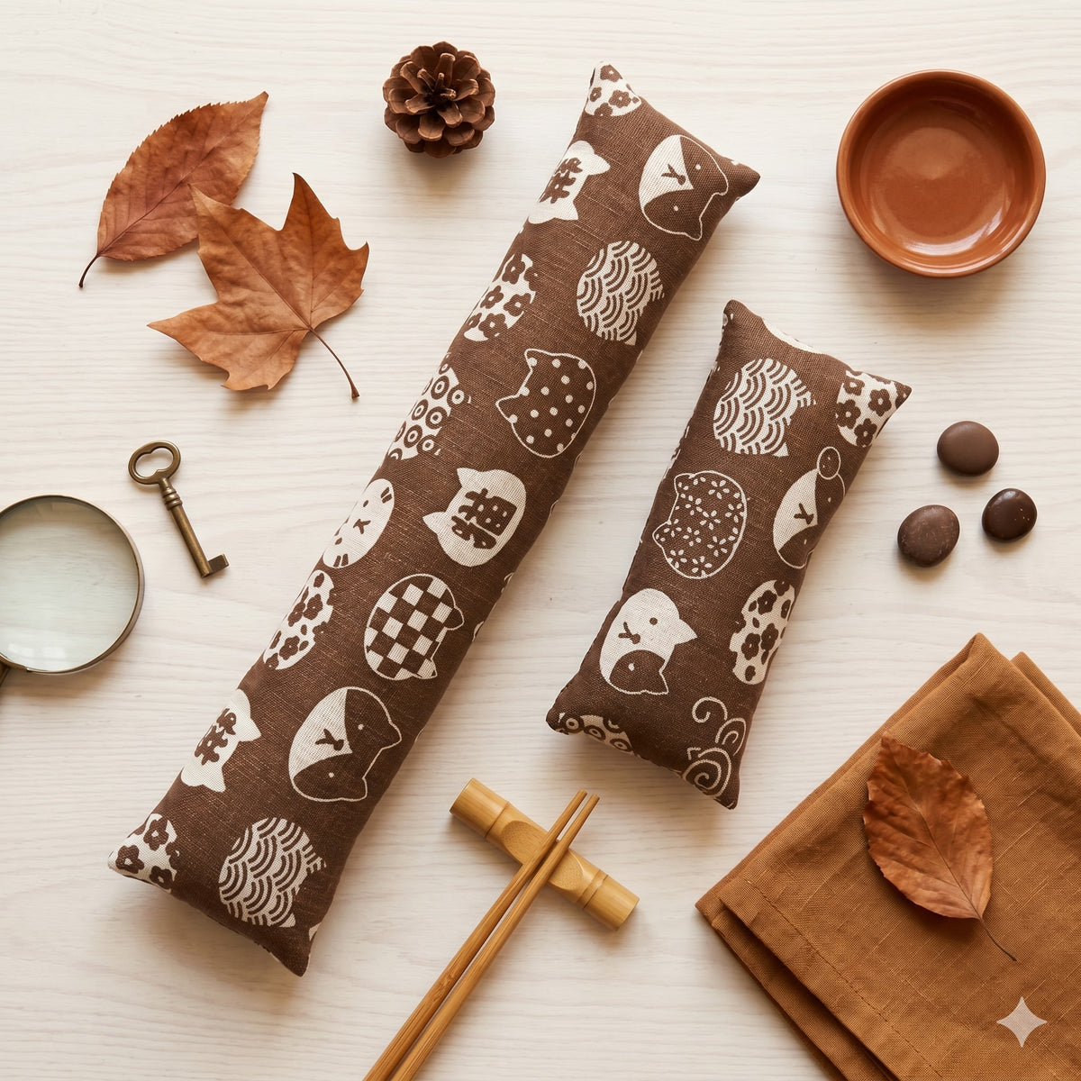 Brown Maneki Neko keyboard and mouse wrist rests with cream cats, laid flat with autumn leaves