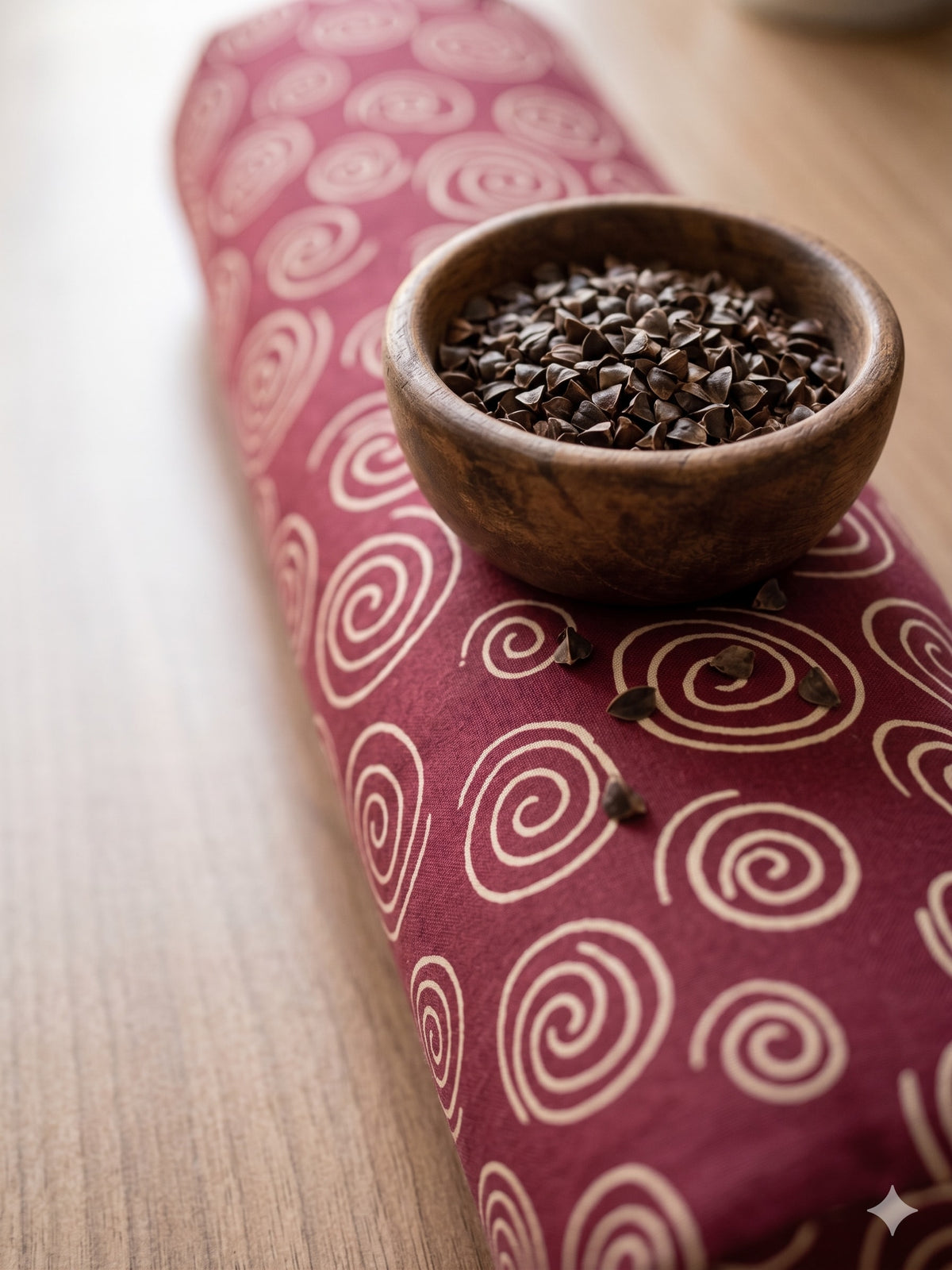 Red spiral wrist rest with a bowl of the buckwheat hulls used as filling