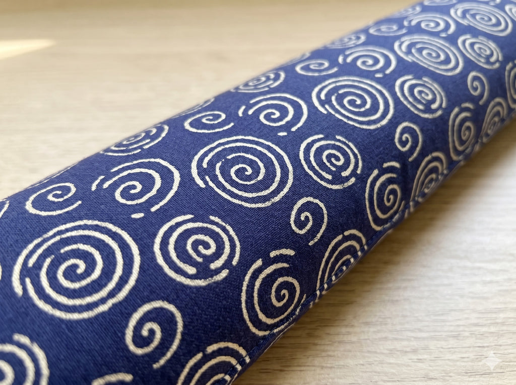 Close-up of cream spirals on indigo blue fabric