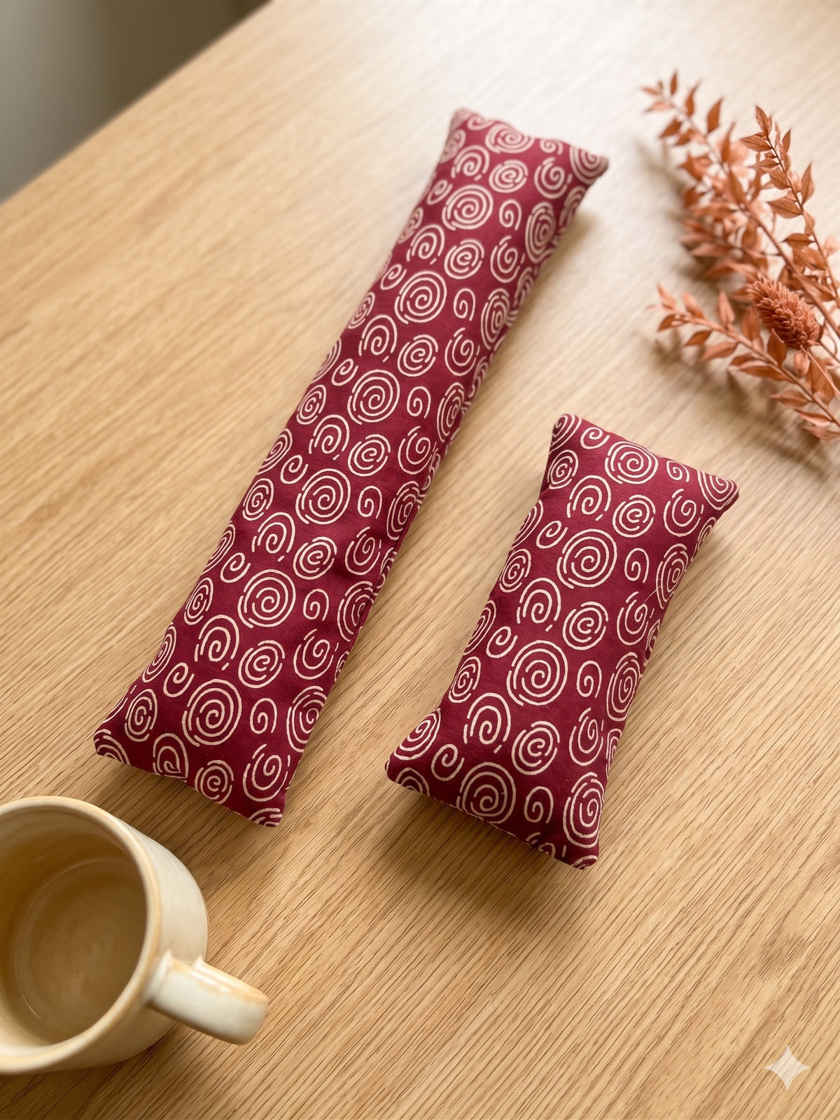 Wine red spiral keyboard and mouse wrist rests on a wooden desk