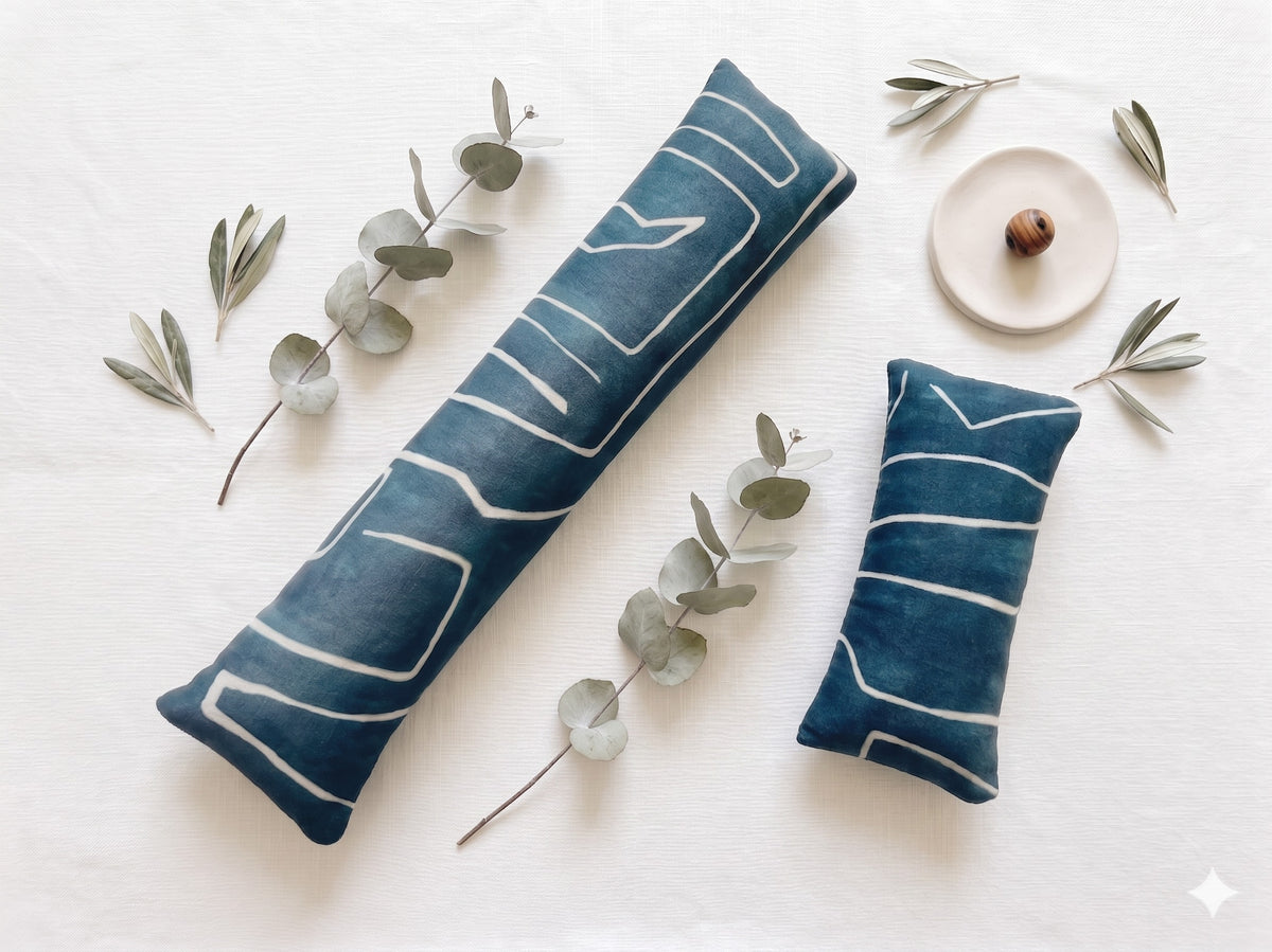 Blue mudcloth pillow velvet keyboard and mouse wrist rests laid flat with sprigs of greenery
