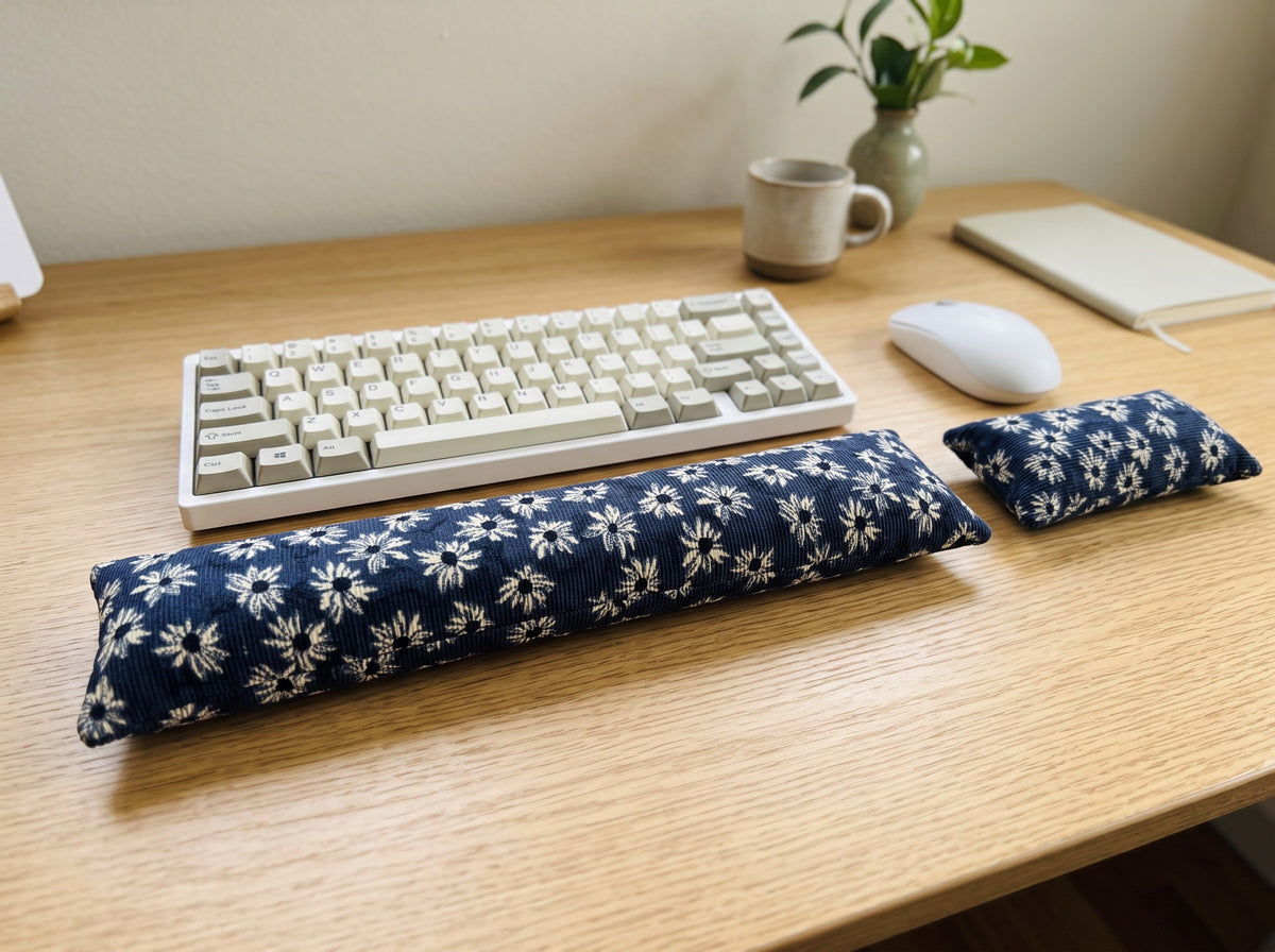 Navy daisy corduroy wrist rest set in front of a keyboard and mouse