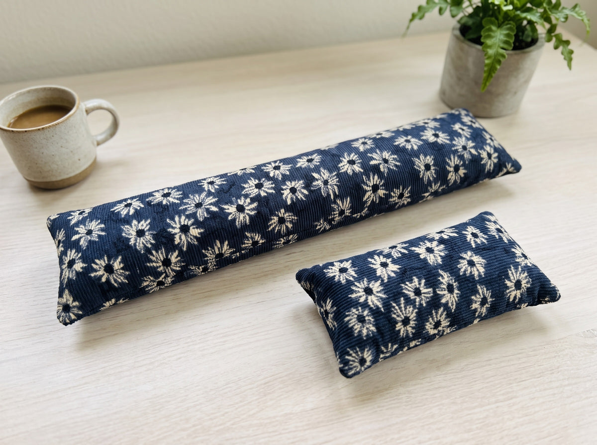 The two pieces of the navy daisy corduroy set, a keyboard wrist rest and a mouse wrist rest
