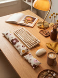 Mocha retro floral cat wrist rests around a keyboard on a sunny, 70s-style desk