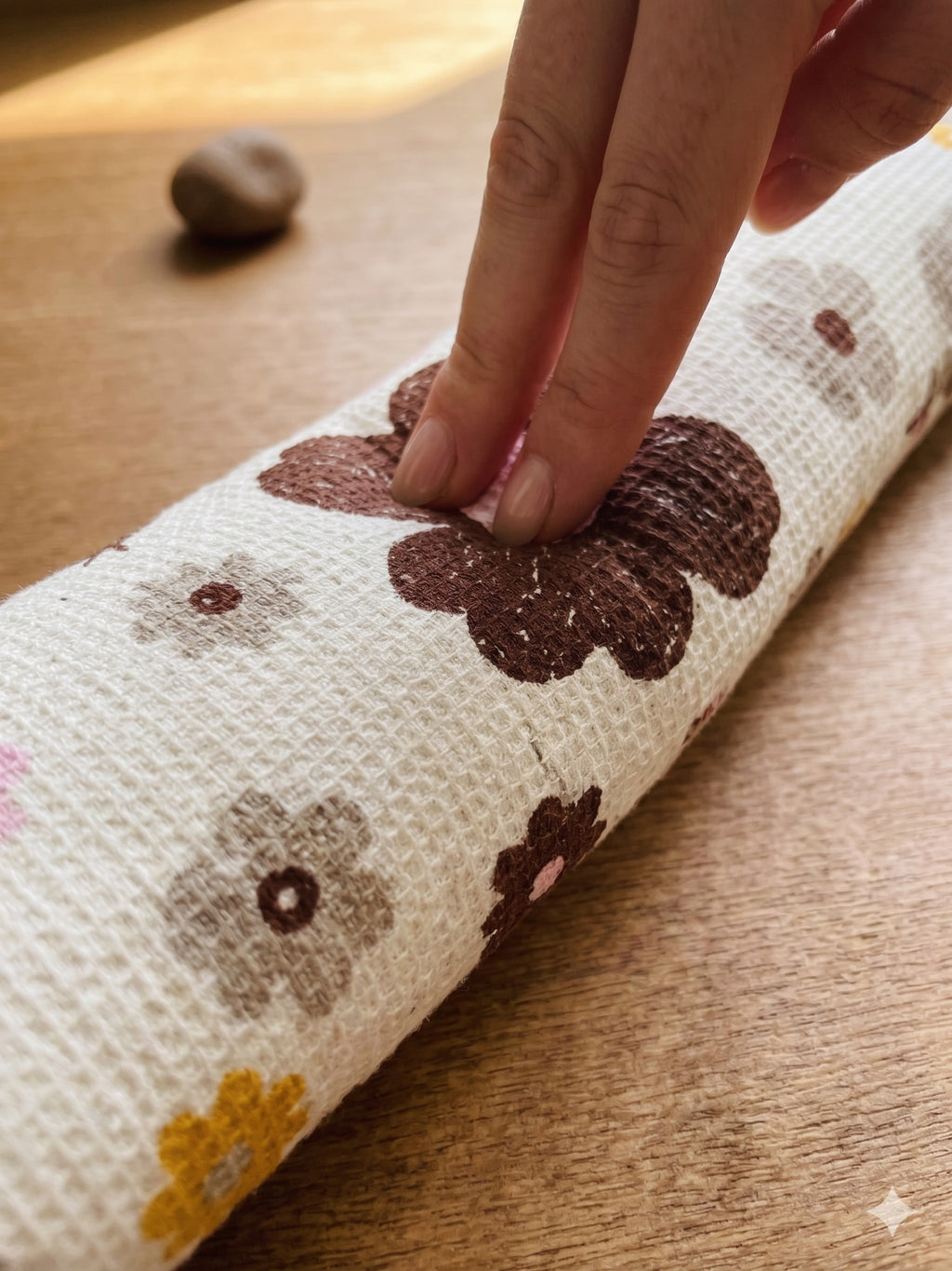 Fingers pressing into the mocha retro floral cat wrist rest to show the buckwheat filling