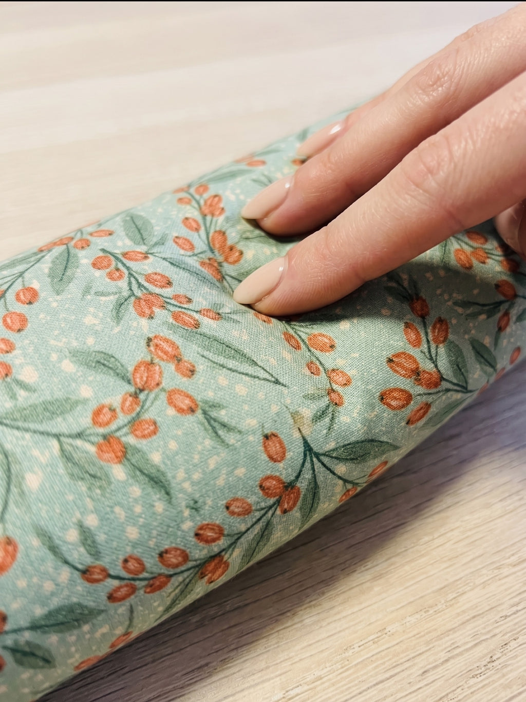 Hand pressing into the sage berry wrist rest to show the buckwheat filling