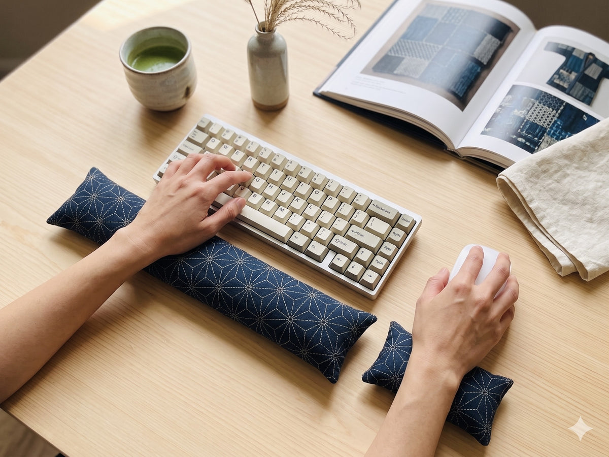 Hands on a keyboard and mouse resting on the indigo sashiko asanoha wrist rests