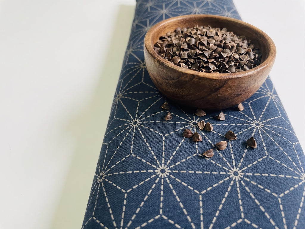 Indigo sashiko wrist rest with a bowl of the buckwheat hulls used as filling