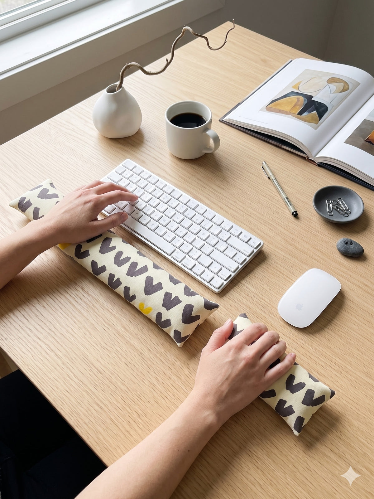 Hands on a keyboard and mouse resting on the scandi abstract wrist rests
