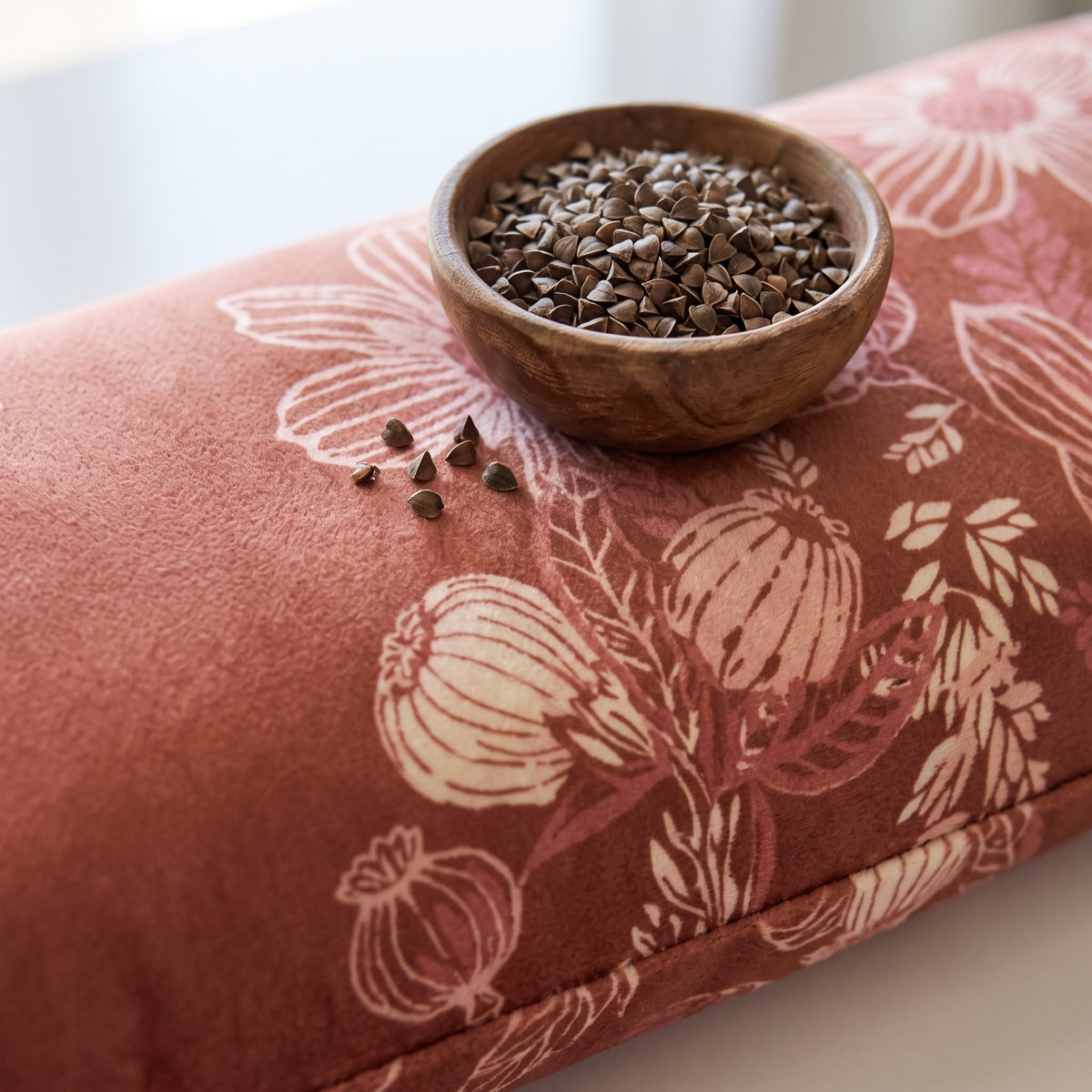 Terracotta velvet wrist rest with a bowl of the buckwheat hulls used as filling