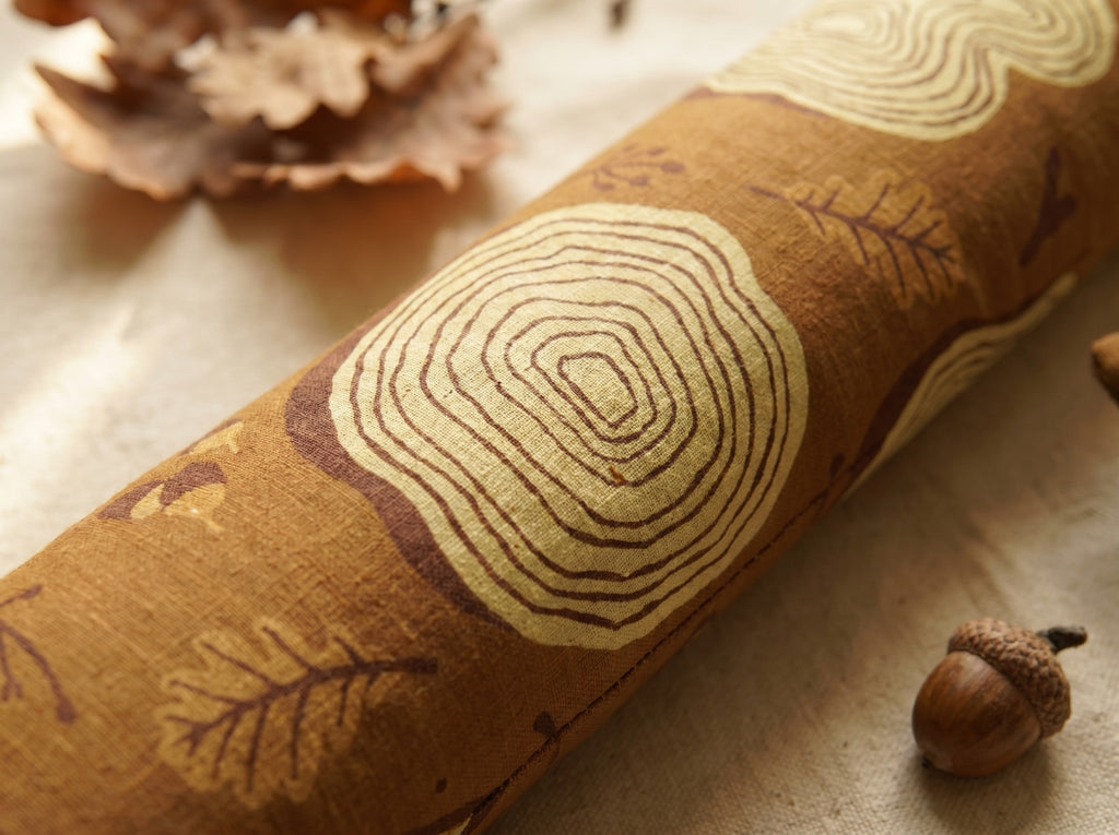 Close-up of a cream tree ring cross-section printed on caramel-brown fabric