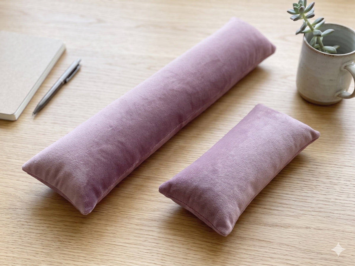 Mauve velvet keyboard and mouse wrist rests on a wooden desk