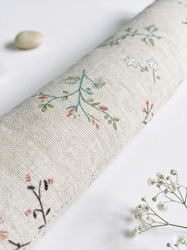 Close-up of coral buds, white blossoms and blue-green leaves on natural fabric
