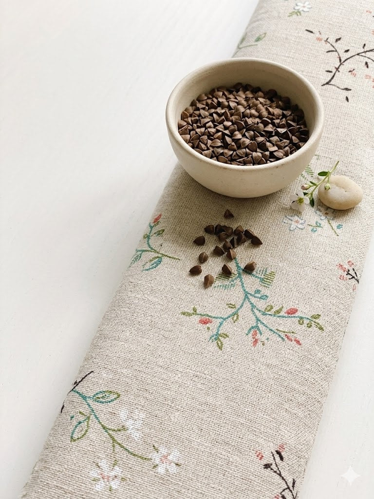 Wildflower sprig wrist rest with a bowl of the buckwheat hulls used as filling