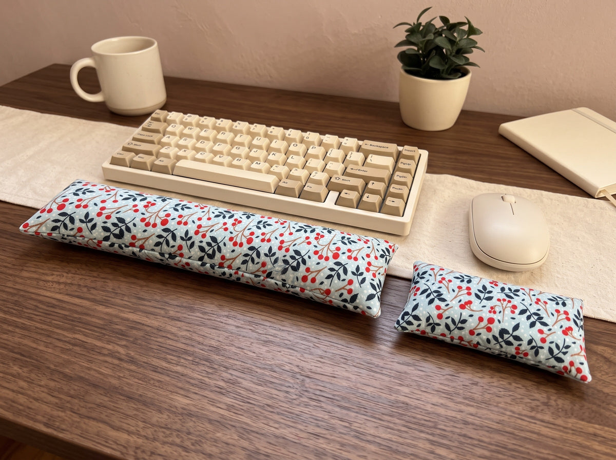 Winterberry wrist rest set in front of a keyboard and mouse on a wooden desk with a plant