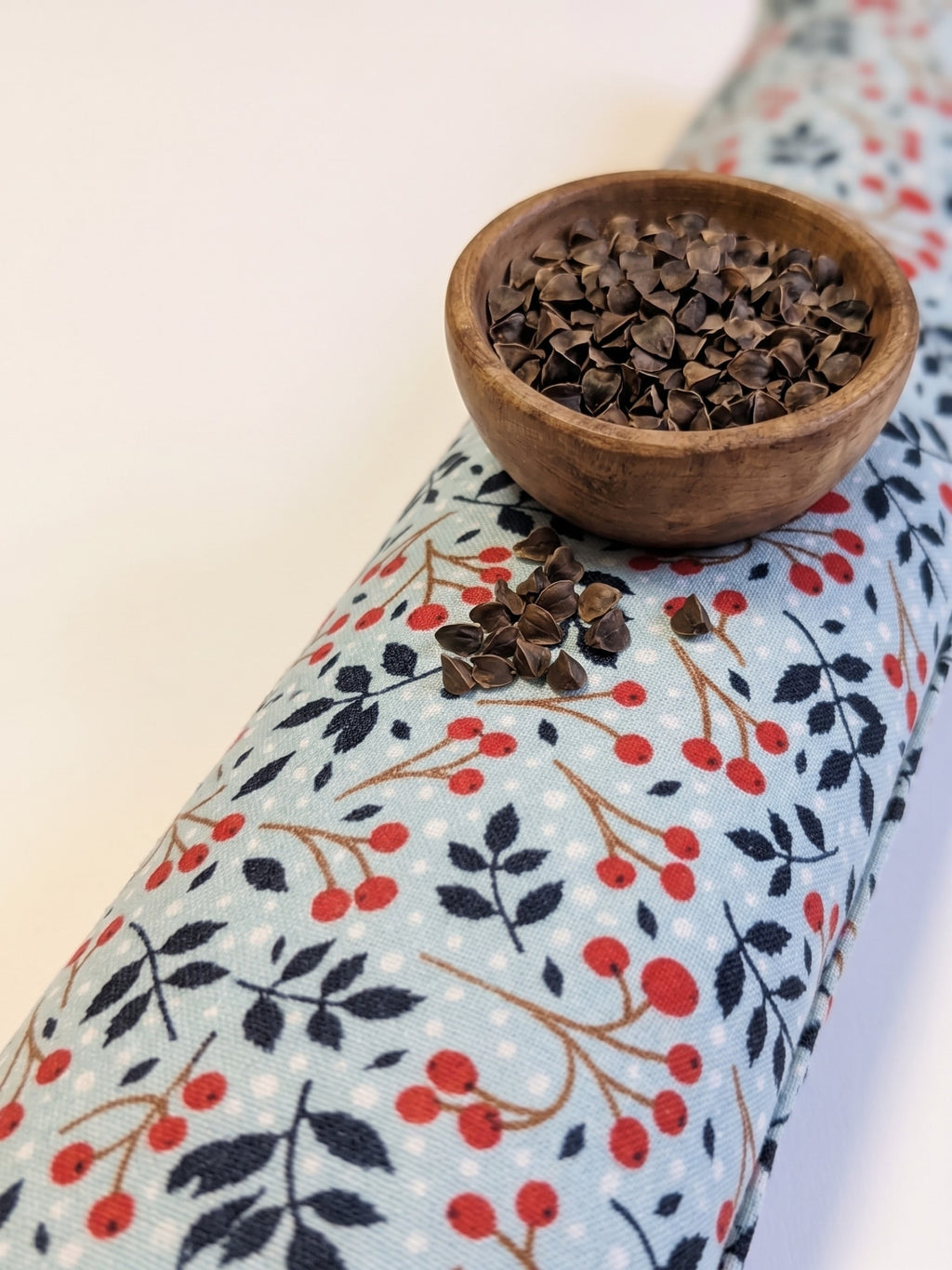 Winterberry wrist rest with a bowl of the buckwheat hulls used as filling