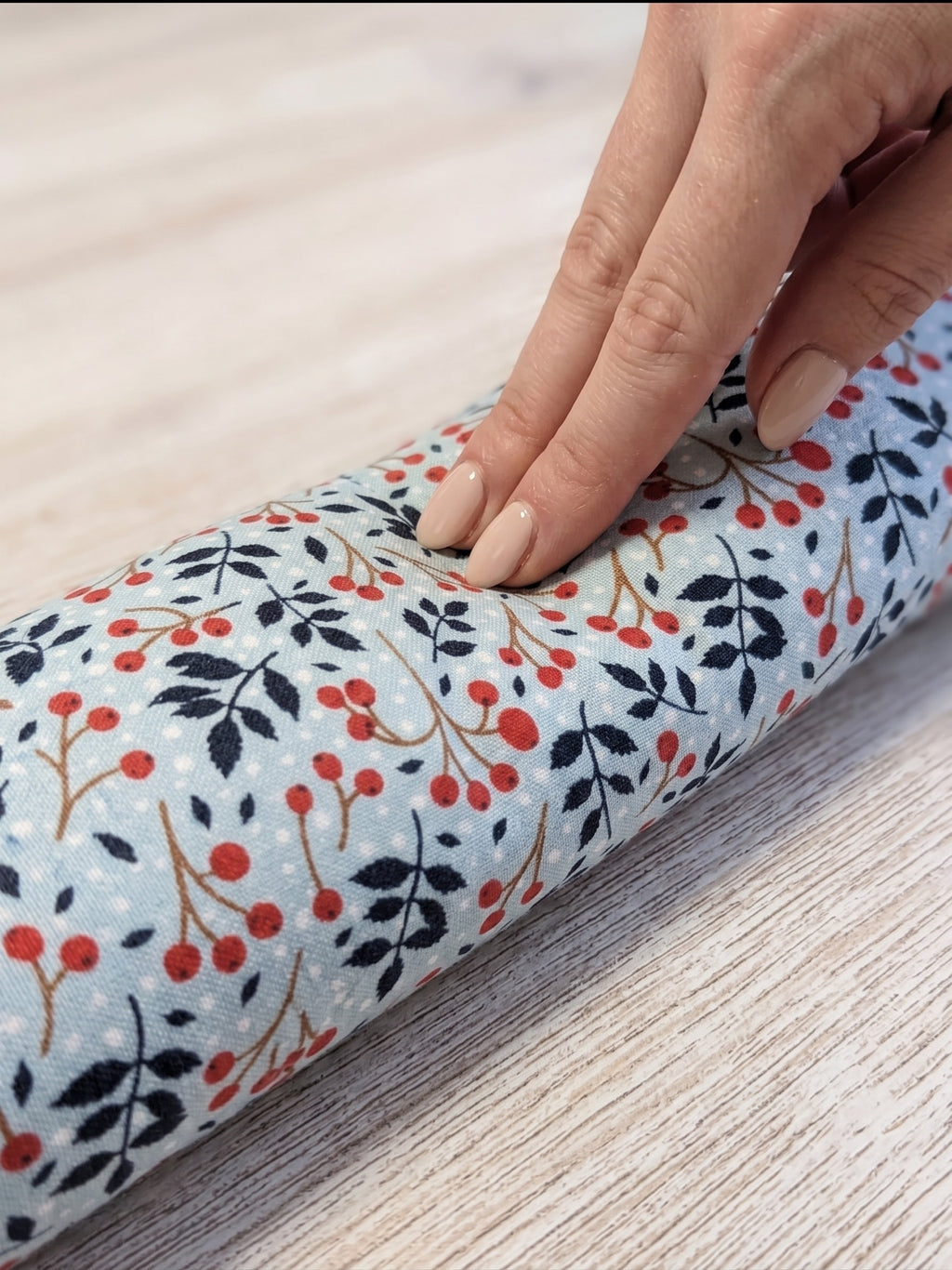 Fingers pressing into the winterberry wrist rest to show the buckwheat filling